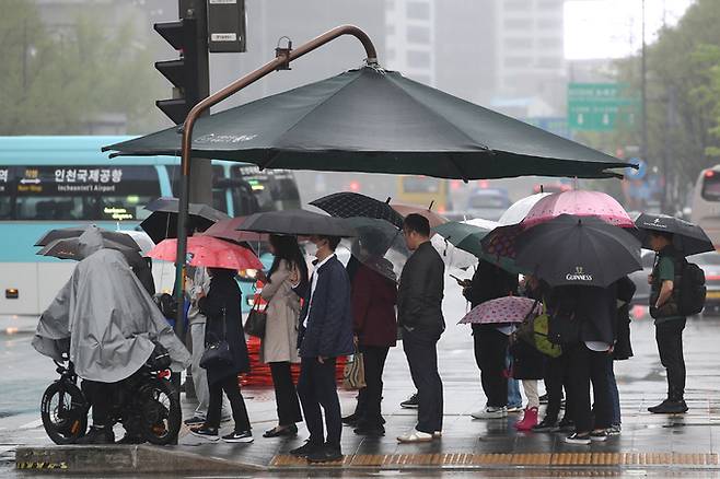 지난 16일 오전 서울 종로구 세종대로 사거리에서 출근길 시민들이 우산을 쓰고 있다. 뉴스1