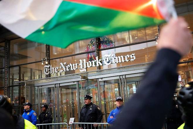지난해 12월18일 미국 뉴욕의 뉴욕타임스 사옥 앞에서 친팔레스타인 활동가들이 시위를 벌이는 동안 경찰이 사옥 입구를 지키고 있다. 뉴욕/AFP 연합뉴스
