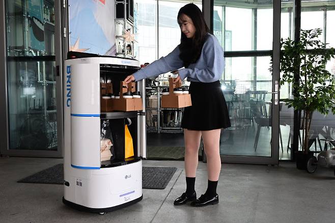 LG전자 모델이 클로이 로봇의 서랍에 배송 물품을 적재하는 모습. (사진=LG전자)