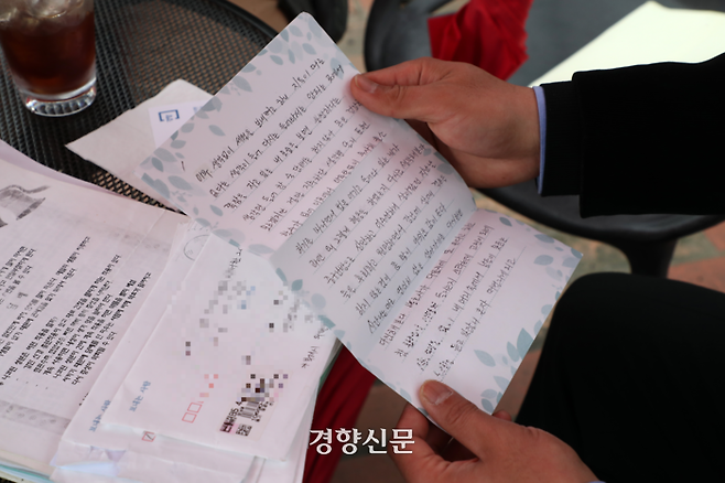 장모씨(56)가 지난 3일 경기 분당의 한 카페에서 경향신문과 인터뷰하며 구치소에서 동생에게 보낸 편지를 보여주고 있다. 정지윤 선임기자
