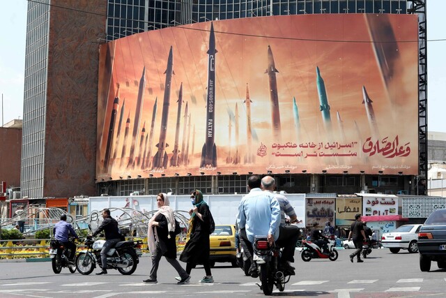 지난 2일 이란 테헤란 시내에 설치된 이란 미사일 사진들 앞을 시민들이 지내가고 있다. 테헤란/AFP 연합뉴스