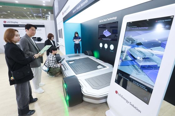 23일 서울 강남구 코엑스에서 열린 '제37회 세계 전기자동차 학술대회 및 전시회(EVS37)'에서 관람객들이 LG에너지솔루션 전기차 배터리 관련 전시품을 관람하고 있다. LG 제공