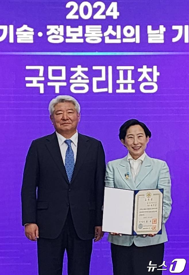 유지연 상명대 교수(오른쪽)가 김홍일 방송통신위원장에게 국무총리 표창을 받고 있다. (상명대 제공)