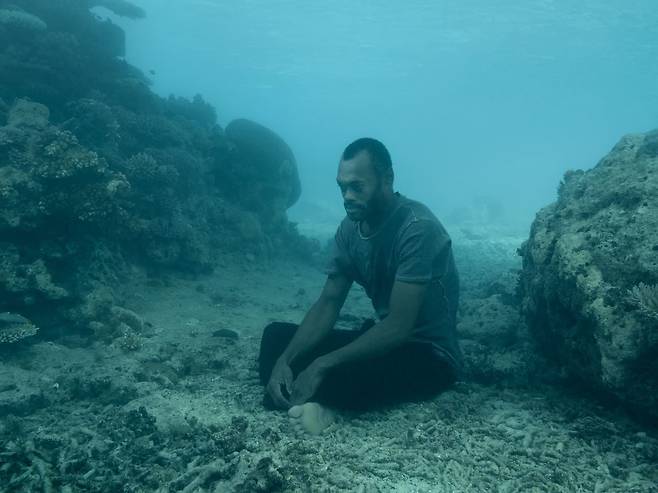 부서진 산호 조각으로 뒤덮인 해저에 자리한 피지 원주민 카마. /@ Nick Brandt