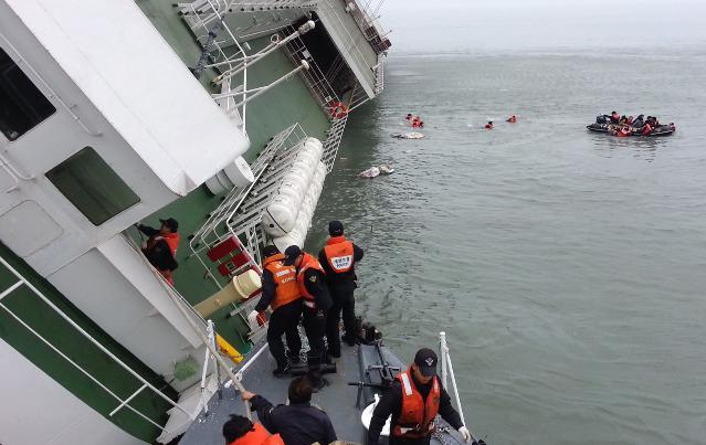 2014년 4월 16일, 해경 요원들이 전복된 세월호에 구조정을 대고 구조 작업을 벌이고 있다. 해경은 승객들을 버리고 도주한 15명의 선원을 배에 태웠다. 해경 제공