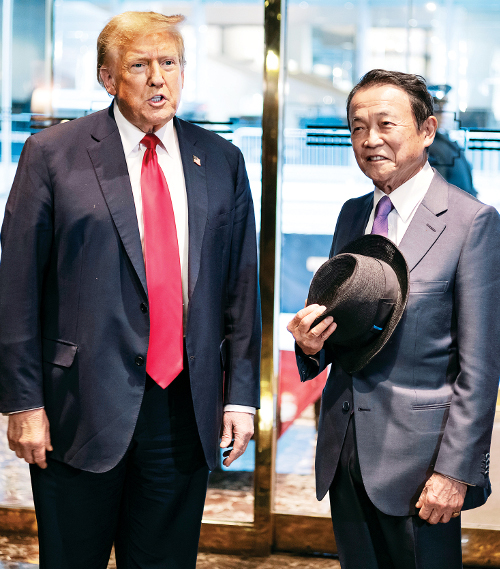 도널드 트럼프 전 미국 대통령이 23일(현지시간) 뉴욕 맨해튼 트럼프타워 출입문에서 아소 다로 일본 자민당 부총재를 맞이하고 있다. AP연합뉴스
