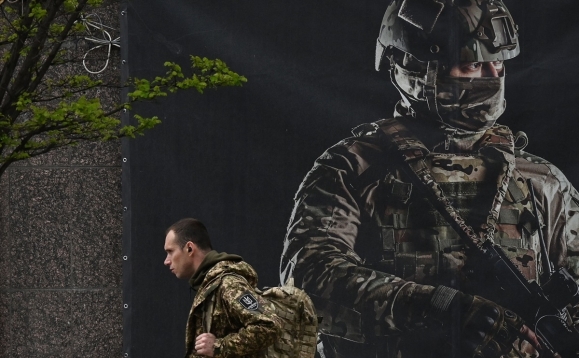 지난 23일 우크라이나의 한 군인이 입대 포스터 앞을 지나가고 있다. AFP 연합뉴스