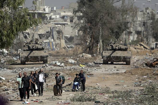 지난해 11월, 이스라엘과 하마스가 4일 동안 휴전을 할 동안 이스라엘 탱크가 가자지구 중앙의 살라 알딘 도로를 막자 팔레스타인인들이 가자 북부에서 도망치고 있다. / AP 연합뉴스