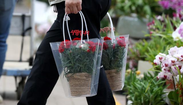 2022년 5월 8일 어버이날을 맞아 서울 서초구 양재 꽃시장에서 시민이 구매한 꽃을 들고 이동하고 있다. 뉴시스