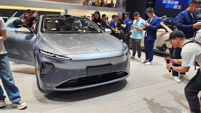 지난 25일 중국 베이징 국제전람센터에서 개막한 '오토차이나 2024'에서 관람객들이 현지 완성차 기업 니오가 공개한 반고체배터리 탑재 전기차 'ET7'을 살펴보고 있다.  박제완 기자