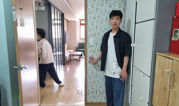 서울 서초구 다니엘복지원에 사는 발달장애인 김현욱씨가 지난 16일 자신의 방과 직접 고른 꽃무늬 벽지를 소개하고 있다.