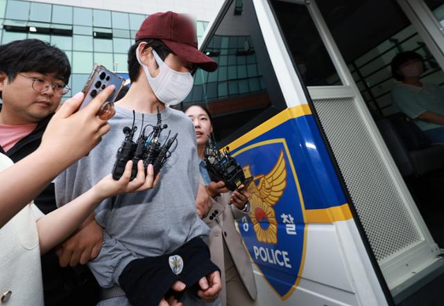 경찰 신고에 불만을 품고 연인을 살해한 혐의로 구속된 김모씨가 서울 금천경찰서에서 검찰로 송치되고 있다. 연합뉴스