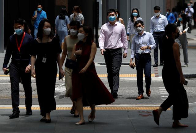 코로나19가 한창이던 2021년 9월 싱가포르에서 직장인들이 마스크를 쓴 채 출근하고 있다. 싱가포르=로이터 연합뉴스 자료사진