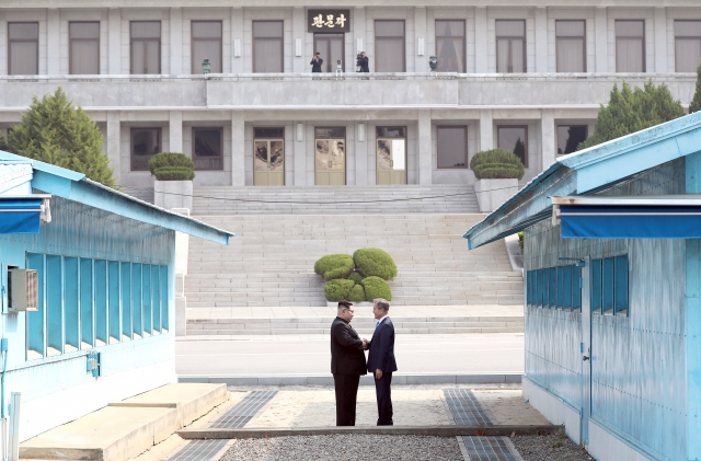 문재인 전 대통령과 김정은 북한 국무위원장이 지난 2018년 4월 27일 오전 판문점에서 북측 지역으로 넘어가 악수하고 있다. 연합뉴스