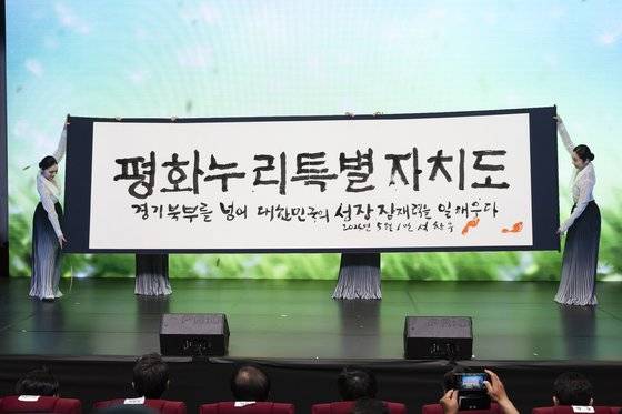 지난 1일 오후 경기도청 북부청사 평화누리홀에서 열린 경기북부특별자치도 새 이름 대국민 보고회에서 석창우 화백이 새 이름 공개 서예 퍼포먼스를 하고 있다. 경기도