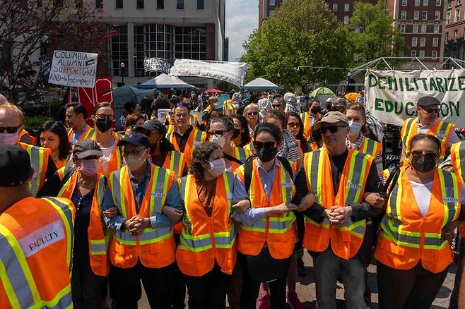 지난달 29일(현지시간) 뉴욕주 컬럼비아대에서 교수들이 해산 위협을 받는 반전 시위대 학생을 보호하기 위해 옆 사람과 팔짱을 끼고 있다. AFP연합뉴스