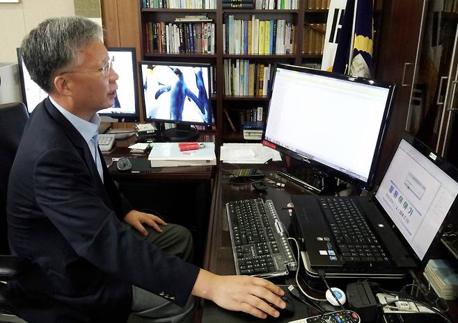 2014년 8월11일 당시 강민구 창원지방법원장이 자신의 집무실에서 4대의 모니터와 노트북, 데스크톱 시스템이 유기적으로 연결된 '멀티태스킹시스템'을 시연하고 있다. ⓒ 연합뉴스
