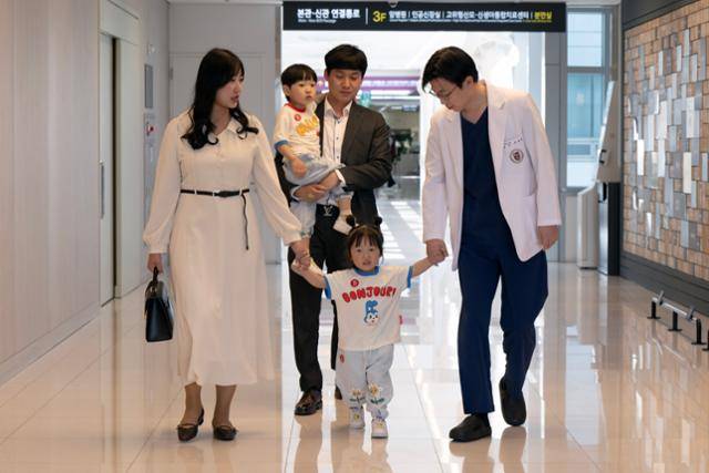 10일 고대구로병원 복도에서 조금준(오른쪽) 산부인과 교수가 장동환(39) 가윤선(33)씨 가족과 함께 걷고 있다. 조 교수는 부부의 둘째 아들 우솔이를 응급 제왕절개 수술로 받아냈다. 박시몬 기자