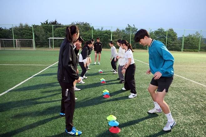프로축구 대전 하나시티즌의 김민기(가운데), 김도윤이 지난 14일 대전 덕암축구센터에서 여성 축구 동호회 ‘세종 니케 FC’ 회원 대상 일일 강습을 하고 있다. 대전 하나시티즌 제공