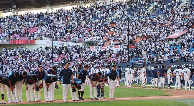 롯데와 두산 선수들이 19일 잠실 맞대결에서 12회 3-3으로 승부를 가리지 못한 뒤 양편 관중을 향해 인사하고 있다. 연합뉴스