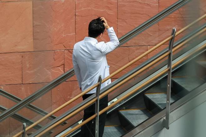 정부의 의대증원안에 반대하는 전공의들이 의료현장을 이탈한지 3개월째인 20일 오전 서울 시내 한 대학병원에서 한 의료관계자가 손으로 머리를 짚고 있다. 연합뉴스 제공