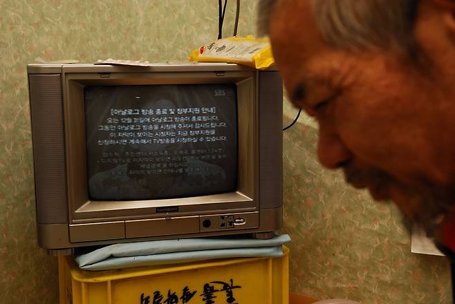 막걸리 박스 위에 낡은 브라운관 텔레비전은 노 씨가 세상과 만나는 유일한 통로였다. 어느 날 아날로그 방송이 종료되어 텔레비전이 나오지 않게 되었다. 통로가 사라졌다. 그는 친구가 필요했다.(2012)/ 사진가 김원