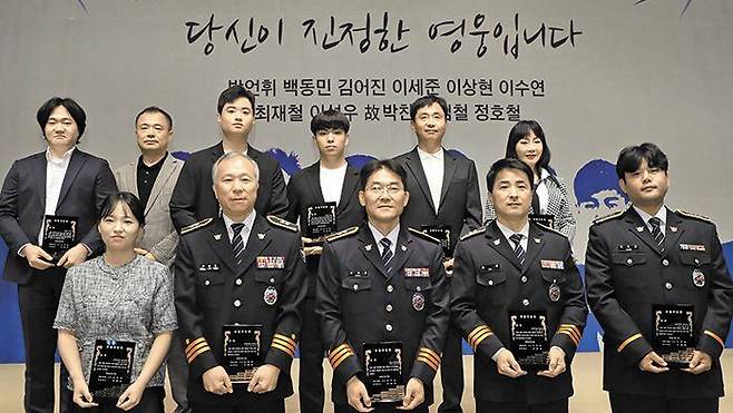 14일 열린 제58회 청룡봉사상 시상식에서 수상자들이 상패를 들고 있다. 앞줄 왼쪽부터 고(故) 박찬준 경위 아내 조아라씨, 이성우 경감, 최재철 경감, 김철 경감, 정호철 경사. 뒷줄 왼쪽부터 이수연·이상현씨, 이세준·김어진군, 백동민씨, 박언휘씨. /장련성 기자
