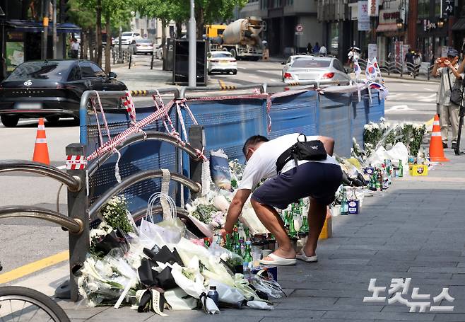 서울 시청역 인근 역주행 참사 이후 사고현장을 찾은 시민들이 희생자를 추모하며 국화를 놓고 있다. 황진환 기자