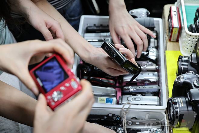 22일 서울 종로구 세운상가 내 중고카메라 매장에서 손님들이 구형 디지털카메라를 살펴보고 있다. 2024.7.22/뉴스1 ⓒ News1 김도우 기자