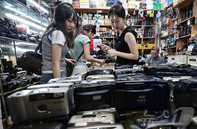 22일 서울 종로구 세운상가 내 중고카메라 매장에서 손님들이 구형 디지털카메라를 살펴보고 있다. 2024.7.22/뉴스1 ⓒ News1 김도우 기자