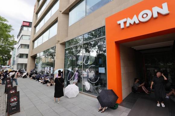 티몬 앞 사측 기다리는 피해자들 - 싱가포르 기반의 전자상거래(이커머스) 플랫폼 큐텐 계열사인 위메프와 티몬 정산 지연 사태가 점차 확산되고 있는 25일 서울 강남구 티몬 본사 앞에서 환불을 원하는 피해자들이 우산을 쓰고 사측을 기다리고 있다. 연합뉴스