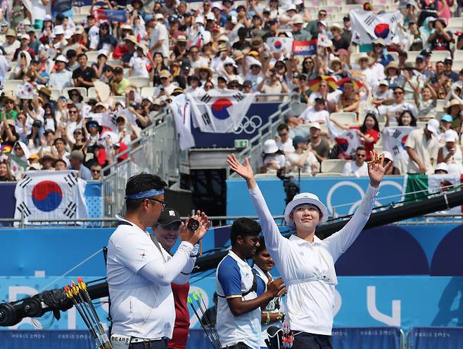 김우진-임시현 짝이 2일(현지시각) 프랑스 파리 레쟁발리드에서 열린 2024 파리올림픽 양궁 혼성 단체 독일과의 결승전에서 선수 소개 때 관중들에게 손들어 인사하고 있다. 파리/연합뉴스