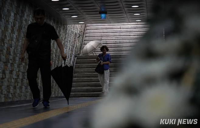 서울 대부분 지역에서 오후 한때 비가 내린 5일 서울 중구 숭례문 지하보도에 마련된 추모공간 근처에서 시민들이 우산을 접으며 이동하고 있다.