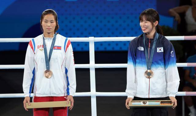 8일(현지시간) 프랑스 파리 롤랑가로스 경기장에서 열린 2024 파리 올림픽 복싱 여자 54㎏급에서 동메달을 획득한 한국 임애지(오른쪽)가 활짝 웃고 있는 반면 북한 방철미는 무덤덤한 표정으로 시상대에 서 있다. 파리=연합뉴스