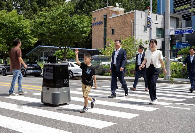 현대차그룹이 자율주행 배송로봇 횡단보도 주행 실증 시연에 성공했다. 9일 경기도 의왕시 부곡파출소 앞 횡단보도에서 열린 '실외 이동로봇 운행 실증 시연회'에서 현대차·기아 로보틱스랩의 자율주행 배송로봇 '달이 딜리버리(DAL-e Delivery)'가 실시간으로 신호 정보를 인지하며 횡단보도를 안전하게 건너고 있다. 달이 딜리버리에는 경찰청의 실시간 교통 신호정보 수집·제공 시스템과 현대차그룹의 실외 이동로봇 관제 시스템을 연동한 기술이 적용됐다. 현대차그룹