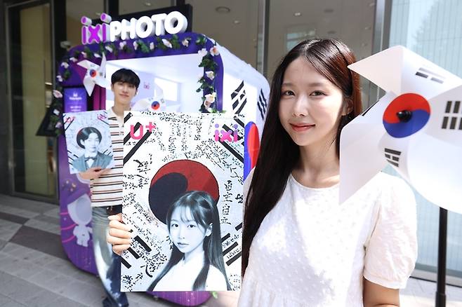 LG유플러스 모델이 서울 마포구 LG유플러스 공덕역점에 설치된 ‘익시 포토부스’에서 촬영한 광복절 콘셉트의 인공지능(AI) 프로필 사진을 보이고 있다. LG유플러스 제공