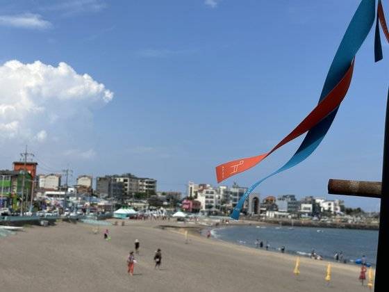 지난 15일 오전 11시 제주올레 17코스 이호해수욕장에서 맨발걷기를 하는 올레꾼들. 최충일 기자