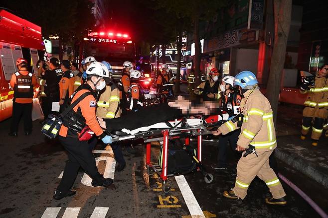 22일 오후 경기도 부천시 원미구 중동의 한 호텔 화재 현장에서 소방대원들이 환자를 이송하고 있다. 이 불로 7명이 숨졌고 다른 투숙객 등 12명이 다쳤다. /연합뉴스
