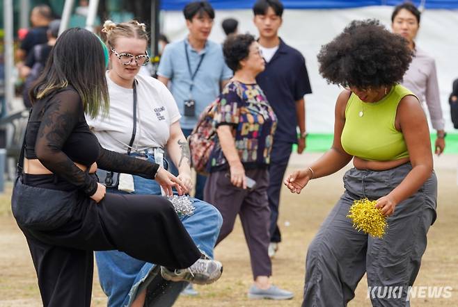 2일 서울 중구 서울광장에서 열린 '2024 추석 농수특산물 서울장터'에서 외국인 관광객들이 제기차기를 하고 있다.