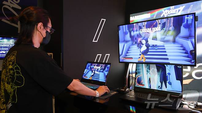 코리안블록체인위크 메인 행사 내 수이 부스에서 이용자가 수이의 게임 콘솔 '수이플레이0X1'을 체험하는 모습.