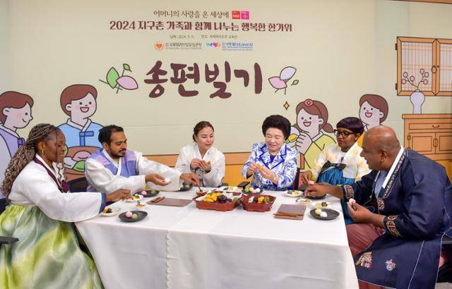 '지구촌 가족과 함께 나누는 행복한 한가위' 행사에 참가한 외국인들이 한복을 입고 장길자(오른쪽 세번째) 회장과 함께 송편을 빚고 있다. 위러브유 제공