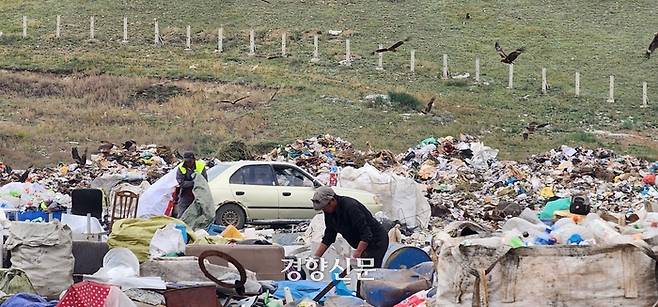 지난달 30일 몽골 수도 울란바토르 인근에 있는 울란촐로트의 쓰레기 적치장에서 주민들이 금속과 플라스틱 등 재활용할 수 있는 물건들을 골라내고 있다. 도시 사람들이 버린 쓰레기더미 속에는 음식 쓰레기도 버려져 있는 탓에 적치장 상공에는 맹금류와 까마귀 등 새들 수백마리가 날아다니고 있었다. 울란촐로트에는 몽골의 급격한 기후변화로 인해 기후난민이 된 유목민 등 도시빈민들이 모여사는 쓰레기마을도 형성돼 있다. 울란바토르 | 김기범 기자