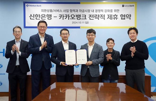 지난 11일 서울 중구 신한은행 본점에서 열린 '카카오뱅크-신한은행 전략적 제휴 협약식'에서 이형주 카카오뱅크 최고비즈니스책임자(오른쪽 세번째)와 김광수 신한은행 고객솔루션그룹장(왼쪽 세번째)이 양 사 관계자들과 함께 함께 기념 촬영을 하는 모습. /사진제공=카카오뱅크