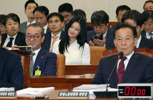 중대재해 관련 증인으로 출석한 정인섭 한화오션 거제사업장 사장이 지난 15일 오후 서울 여의도 국회 환경노동위원회에서 열린 경제사회노동위원회 등에 대한 국정감사에서 '직장 내 따돌림'을 증언하러 나온 '뉴진스'의 하니와 셀카를 찍고 있다. /뉴시스