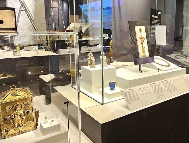 ‘실크로드’전을 열고 있는 브리티시박물관 솔즈베리관 4번째, 5번째 진열장의 신라 실크로드 유물들. 맨 오른쪽에 경주 계림로 14호분 출토 황금장식 보검이 놓였고, 그 옆으로 경주 용강동 출토 서역인과 문관의 토용(흙인형), 감은사 터 동탑의 사리장엄구가 잇따라 진열된 모습이 보인다. 전시 개막 전 준비 과정에서 찍은 것이다. 국립경주박물관 제공