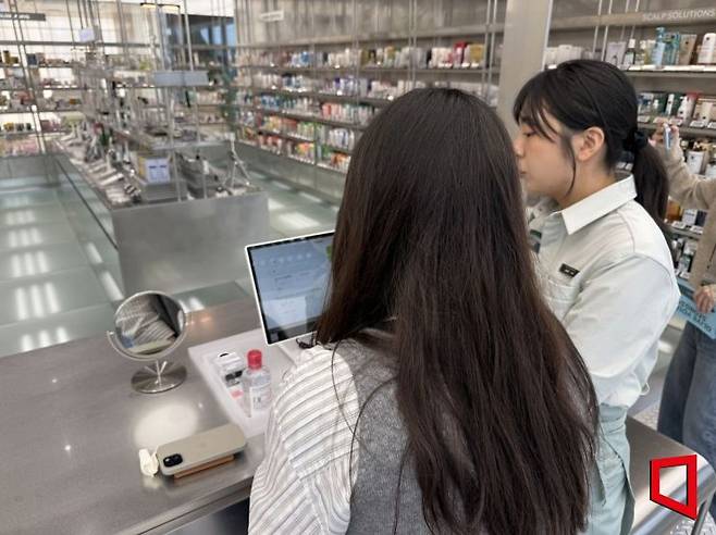 올리브영N 성수를 찾은 고객이 피부 진단을 받은 뒤 스킨케어 방법을 교육받고 있다. 이명환 기자