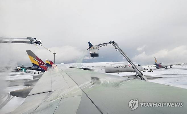 폭설 첫눈에 항공기 운항도 비상 (영종도=연합뉴스) 성연재 기자 = 폭설이 내린 27일 오전 영종도 인천국제공항 1터미널에서 인천발 나고야행 아시아나항공 여객기 날개의 눈을 녹이는 작업이 이뤄지고 있다. 2024.11.27 polpori@yna.co.kr