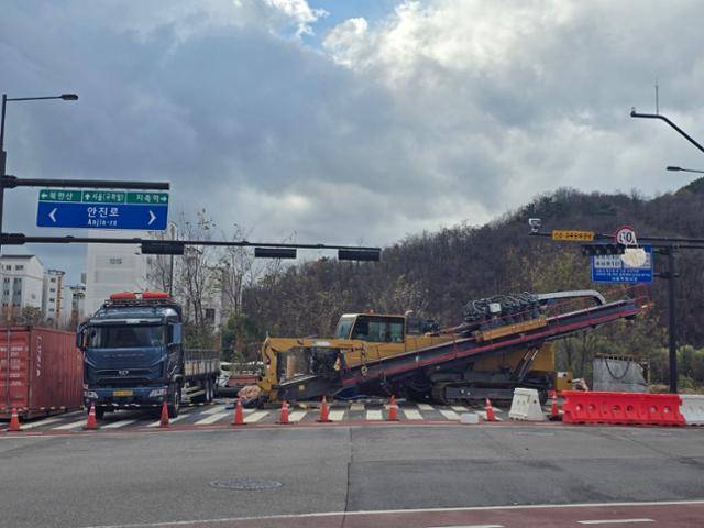 2011년 광역교통대책 일환으로 추진된 창릉천 횡단교량이 13년 넘도록 설치되지 않아 시민들이 불편을 겪고 있다. 지난달 24일 설치돼야 할 교량 대신 직진 가능 교통표지판 아래 건설기계가 입구를 막고 있다. 임명수 기자