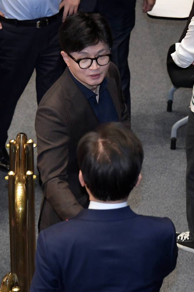 윤석열 대통령이 3일 밤 긴급성명을 통해 비상계엄을 선포한 가운데 4일 새벽 서울 여의도 국회 본회의장에서 국민의힘 한동훈 대표와 더불어민주당 이재명 대표가 만나 인사하고 있다. ⓒ연합뉴스