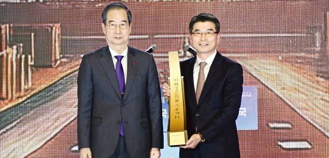 5일 서울 삼성동 코엑스에서 열린 제61회 무역의날 기념식에서 한덕수 국무총리(왼쪽)는 송호성 기아 사장에게 250억달러 수출의 탑을 전달했다. /기아 제공